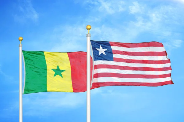 Senegal Libéria Duas Bandeiras Postes Bandeira Azul Céu Nublado Fundo — Fotografia de Stock