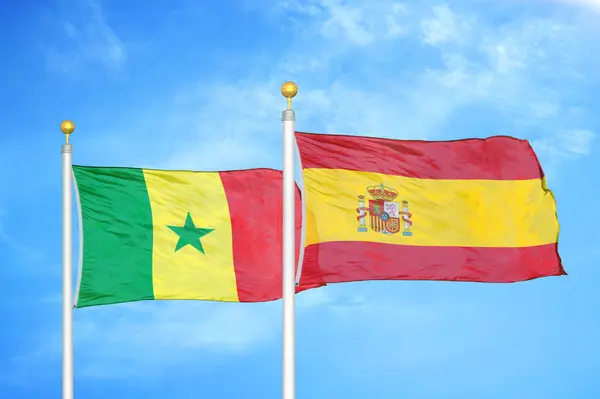 Senegal Espanha Duas Bandeiras Postes Bandeira Azul Céu Nublado Fundo — Fotografia de Stock