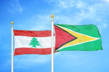 Lübnan ve Guyana bayrak direkleri ve mavi bulutlu arka planda iki bayrak
