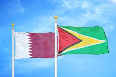 Katar ve Guyana bayrak direkleri üzerinde iki bayrak ve mavi bulutlu arka plan