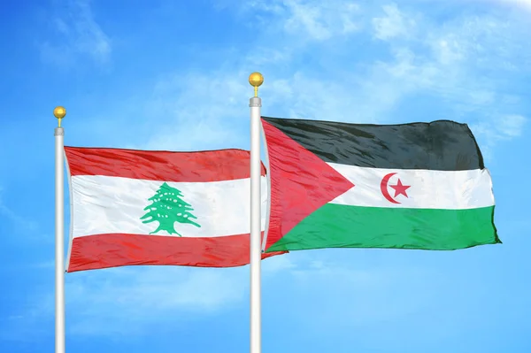 Lebanon and Western Sahara two flags on flagpoles and blue cloudy sky background