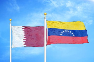 Katar ve Venezuela bayrak direkleri ve mavi bulutlu arka planda iki bayrak