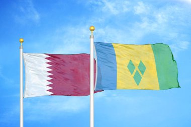 Katar ve Saint Vincent ve Grenadines bayrak direkleri üzerinde iki bayrak ve mavi bulutlu arka plan