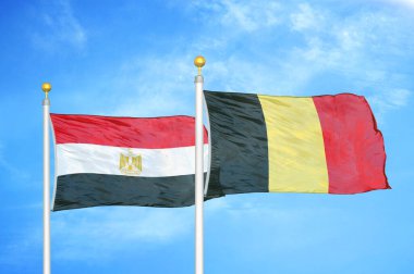Mısır ve Belçika bayrak direkleri ve mavi bulutlu arka planda iki bayrak