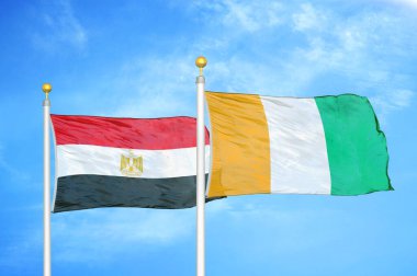 Mısır ve Fildişi Fildişi Sahilleri bayrak direkleri ve mavi bulutlu arka planda iki bayrak