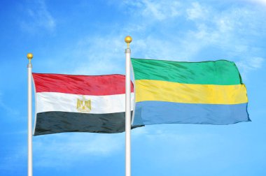Mısır ve Gabon bayrak direkleri üzerinde iki bayrak ve mavi bulutlu arka plan
