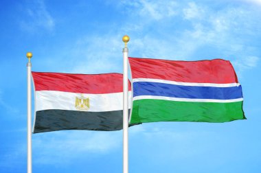 Mısır ve Gambiya bayrak direkleri üzerinde iki bayrak ve mavi bulutlu arka plan