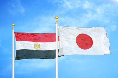 Mısır ve Japonya bayrak direkleri üzerinde iki bayrak ve mavi bulutlu arka plan
