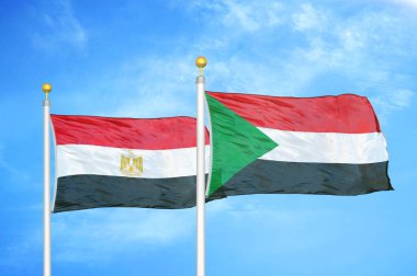 Mısır ve Sudan bayrak direkleri üzerinde iki bayrak ve mavi bulutlu arka plan