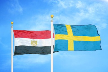 Mısır ve İsveç bayrak direkleri üzerinde iki bayrak ve mavi bulutlu arka plan