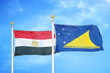 Mısır ve Tokelau bayrak direkleri üzerinde iki bayrak ve mavi bulutlu arka plan