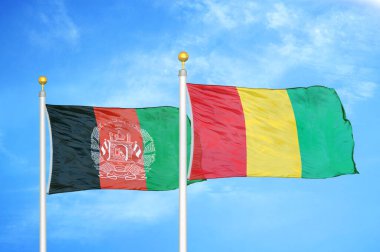 Afganistan ve Gine bayrak direkleri ve mavi bulutlu arka planda iki bayrak