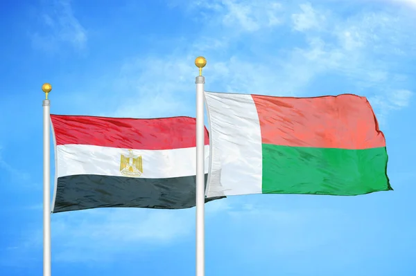Egito Madagascar Duas Bandeiras Postes Bandeira Azul Céu Nublado Fundo — Fotografia de Stock