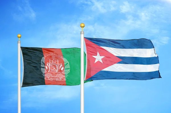 Afghanistan and Cuba  two flags on flagpoles and blue cloudy sky background