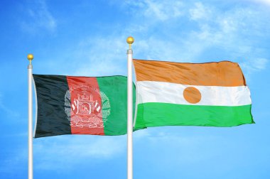 Afganistan ve Nijer bayrak direkleri üzerinde iki bayrak ve mavi bulutlu arka plan
