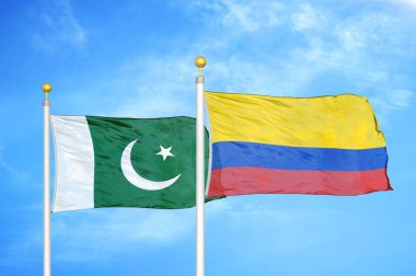 Pakistan ve Kolombiya bayrak direkleri üzerinde iki bayrak ve mavi bulutlu arka plan