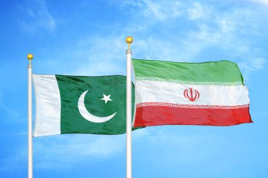 Pakistan ve İran bayrak direkleri ve mavi bulutlu arka planda iki bayrak