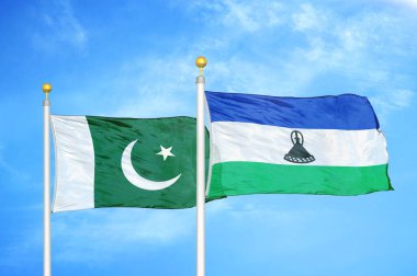 Pakistan ve Lesotho bayrak direkleri ve mavi bulutlu arka planda iki bayrak
