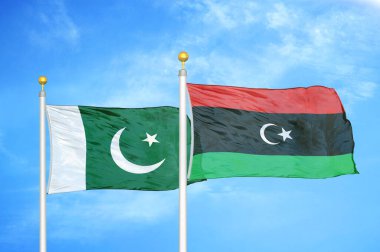 Pakistan ve Libya bayrak direkleri ve mavi bulutlu arka planda iki bayrak