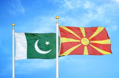 Pakistan ve Kuzey Makedonya bayrak direkleri ve mavi bulutlu arka planda iki bayrak