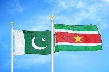 Pakistan ve Surinam bayrak direkleri üzerinde iki bayrak ve mavi bulutlu arka plan