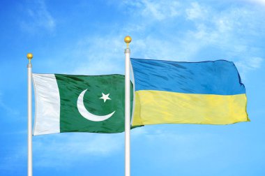 Pakistan ve Ukrayna bayrak direkleri ve mavi bulutlu arka planda iki bayrak
