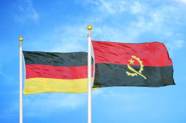 Almanya ve Angola bayrak direkleri ve mavi bulutlu arka planda iki bayrak
