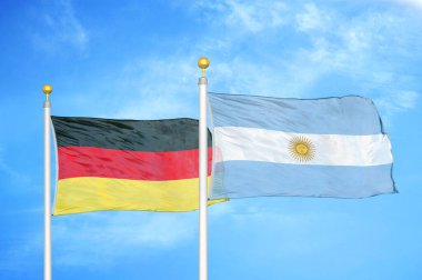 Almanya ve Arjantin bayrak direkleri üzerinde iki bayrak ve mavi bulutlu arka plan