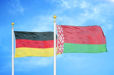 Almanya ve Belarus bayrak direkleri ve mavi bulutlu arka planda iki bayrak