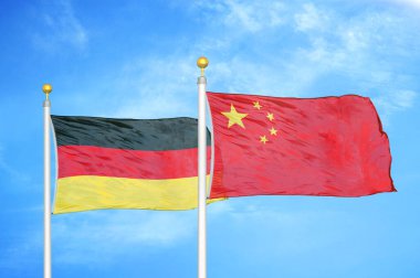 Almanya ve Çin bayrak direkleri ve mavi bulutlu arka planda iki bayrak