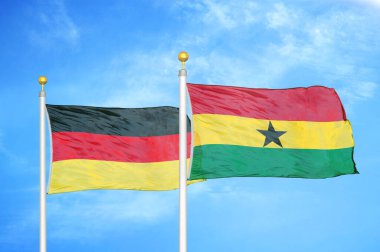Almanya ve Gana bayrak direkleri ve mavi bulutlu arka planda iki bayrak