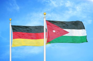 Almanya ve Ürdün bayrak direkleri üzerinde iki bayrak ve mavi bulutlu arka plan