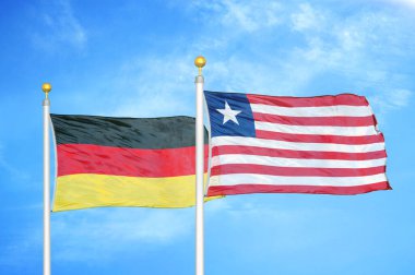 Almanya ve Liberya bayrak direkleri ve mavi bulutlu arka planda iki bayrak