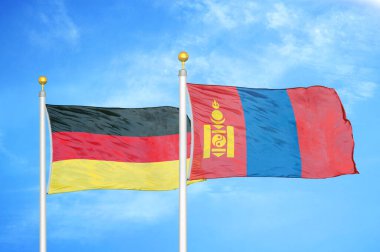 Almanya ve Moğolistan bayrak direkleri ve mavi bulutlu arka planda iki bayrak