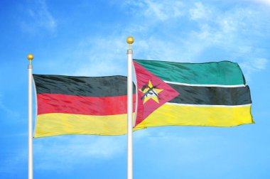 Almanya ve Mozambik bayrak direkleri ve mavi bulutlu arka planda iki bayrak