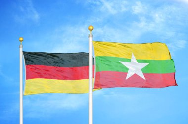 Almanya ve Myanmar bayrak direkleri ve mavi bulutlu arka planda iki bayrak