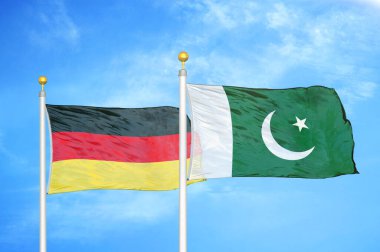 Almanya ve Pakistan bayrak direkleri üzerinde iki bayrak ve mavi bulutlu arka plan