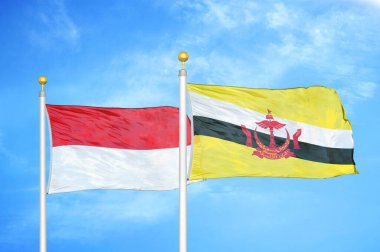 Endonezya ve Brunei Darussalam bayrak direkleri üzerinde iki bayrak ve mavi bulutlu arka plan