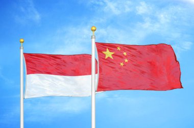 Endonezya ve Çin bayrak direkleri ve mavi bulutlu arka planda iki bayrak