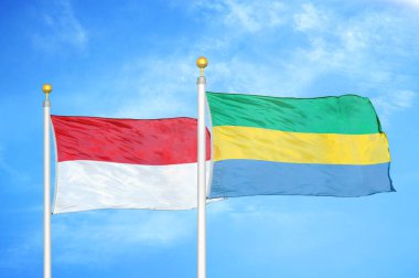 Endonezya ve Gabon bayrak direkleri ve mavi bulutlu arka planda iki bayrak