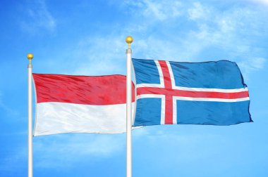 Endonezya ve İzlanda bayrak direkleri ve mavi bulutlu arka planda iki bayrak