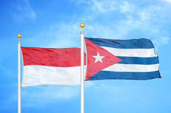 インドネシアとキューバの旗竿と青空の背景に2つの旗 — ストック写真