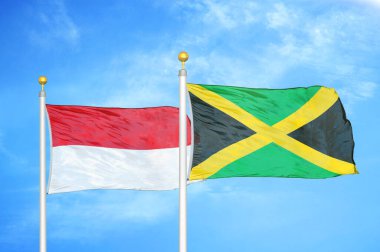 Endonezya ve Jamaika bayrak direkleri ve mavi bulutlu arka planda iki bayrak