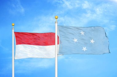 Endonezya ve Mikronezya bayrak direkleri üzerinde iki bayrak ve mavi bulutlu arka plan