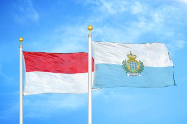 Endonezya ve San Marino bayrak direkleri ve mavi bulutlu arka planda iki bayrak