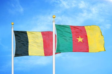 Belçika ve Kamerun bayrak direkleri ve mavi bulutlu arka planda iki bayrak