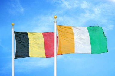 Belçika ve Fildişi Fildişi Sahilleri bayrak direkleri ve mavi bulutlu arka planda iki bayrak