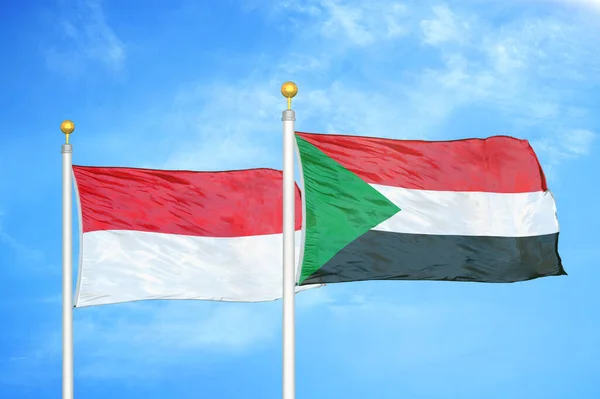 Indonésia Sudão Duas Bandeiras Postes Bandeira Azul Céu Nublado Fundo — Fotografia de Stock