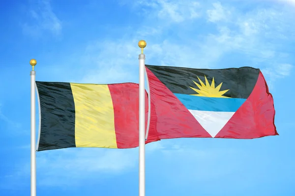 比利时和安提瓜和巴布达旗杆上的两面旗帜和蓝天背景 — 图库照片