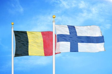 Belçika ve Finlandiya bayrak direkleri ve mavi bulutlu arka planda iki bayrak